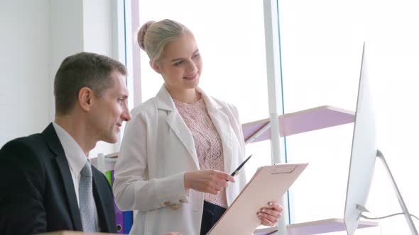 Two Business People Talk Project Strategy at Office