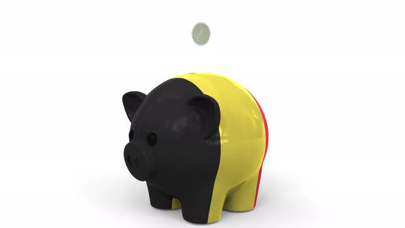 Coins Fall Into Piggy Bank Painted with Flag of Belgium