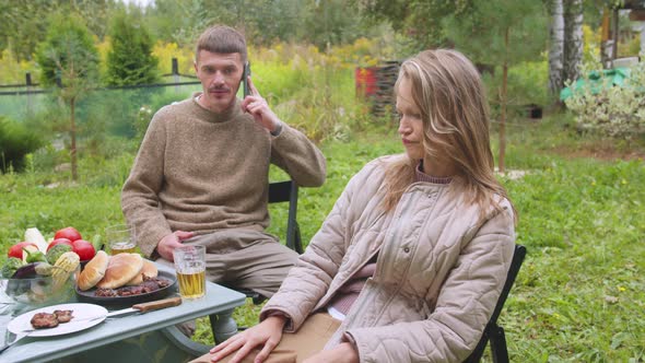 The Girl's Facial Expression Shows His Discontent with the Fact That the Man Talking on the Phone