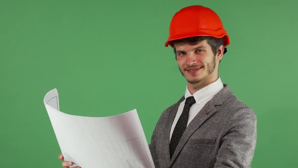 Happy Architect Examining His Blueprints Smiling Joyfully