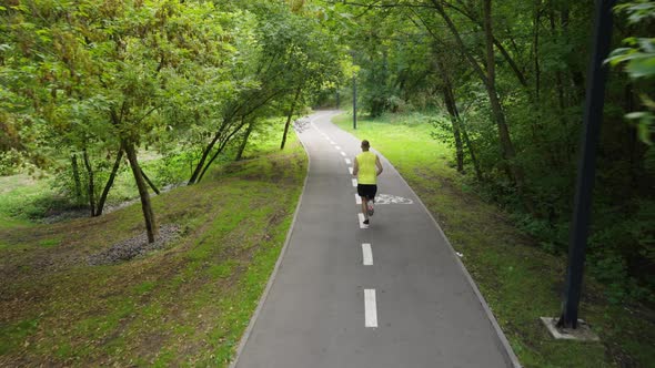 Man Jogging on Road with Marking