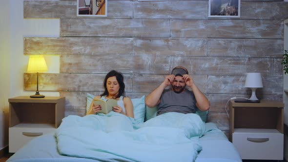 Woman Reading a Book Wearing Pajamas in Bedroom