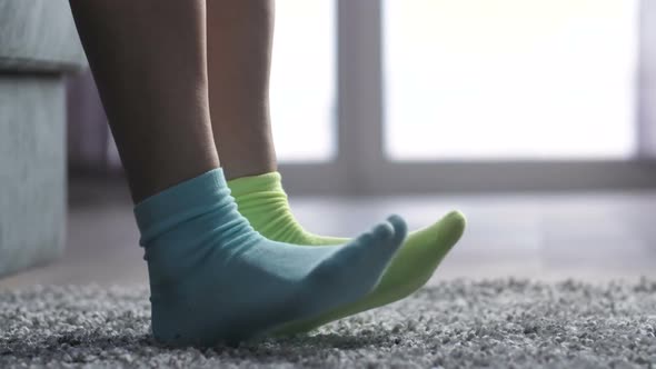  Woman Putting on Different Colored Socks