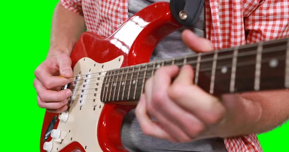 Mid section of male musician playing guitar