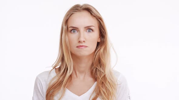 Young Beautiful Caucasian Blonde Girl Actively Diasagrees Wonders Puzzles on White Background