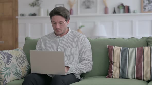 Man Working on Laptop on Sofa