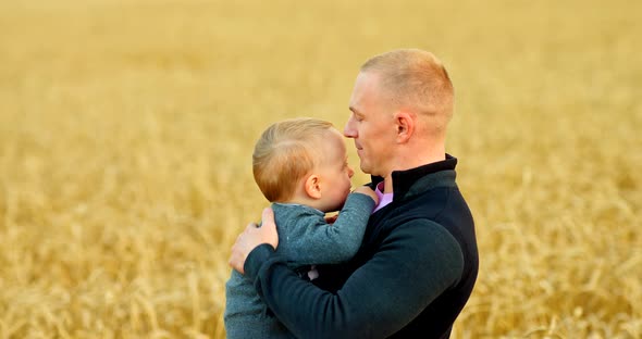 Caring Dad Holds His Son in His Arms and Strokes His Head Kisses and Smiles