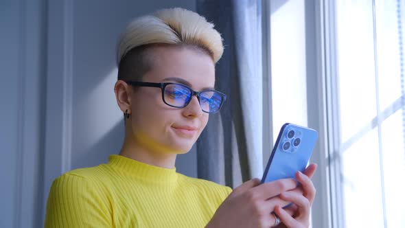 Young tomboy female using new mobile phone for communication online in 4k video