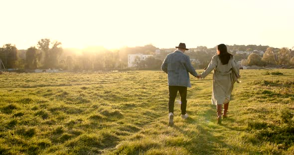 Rear View of Couple Holding Hands in Nature