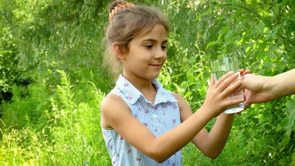 Child Girl Drinks Water From a Glass