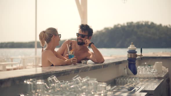 Romantic Couple Drinking Beer On Bar Counter. Honeymoon Lovers Vacation Travel In Greek Resort.