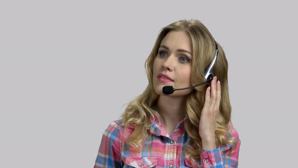 Young Female Operator with Headset Helping Client on Hotline