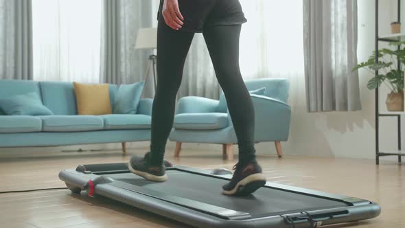 Back View Legs Of Asian Woman Training On Walking Treadmill At Home
