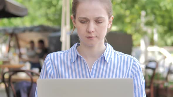 Young Woman Talking on Phone While Sitting in Cafe Terrace