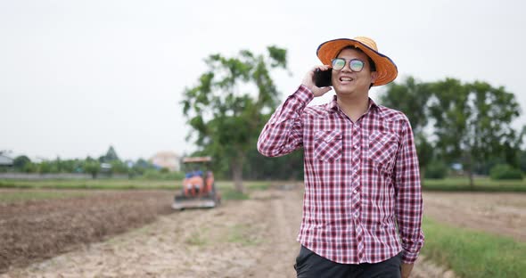 Farmer phone talking at farm have tractor