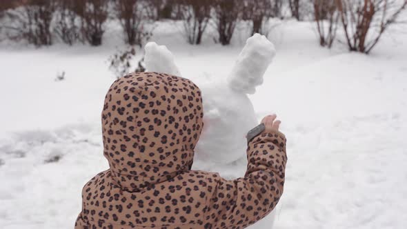 Child is Playing on Winter Snowy Day