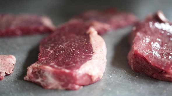 Chef greases raw barbecue meat with olive oil