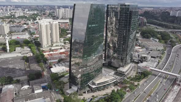 Mirrored two Building and Clouds with cars and river drone 4k