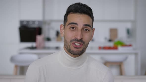 Positive Cheerful Young Middle Eastern Man Waving Smiling Talking Looking at Camera