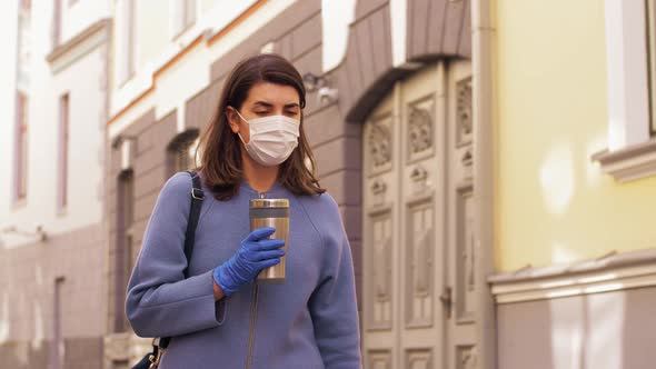 Woman in Medical Mask with Tumbler Walking in City