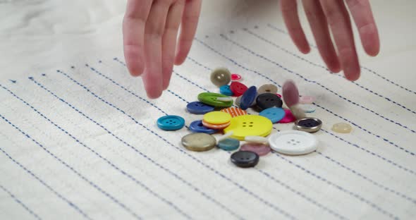 Colorful Buttons Falling on Striped Fabric Closeup