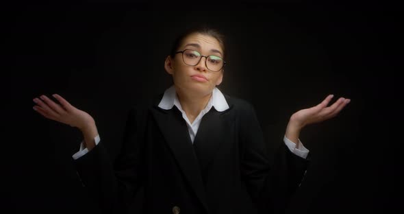 Business Woman with Glasses Shrugs Her Shoulders