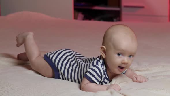 Toddler baby boy smiles at the camera. Newborn Playful and energetic child