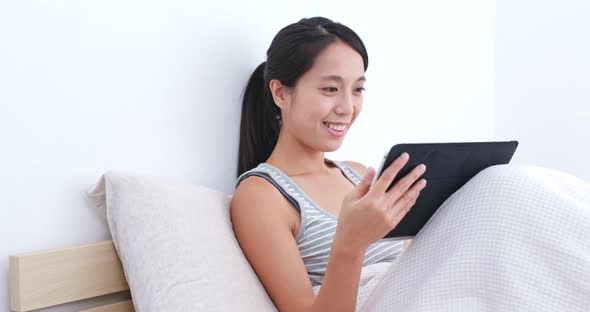 Woman watching tablet on bed