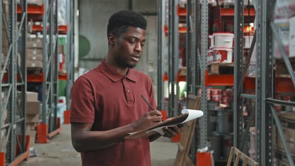 Black Male Supervisor Taking Stock in Warehouse