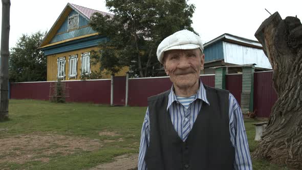 Portrait of an Old Grandfather Near His House in the Village