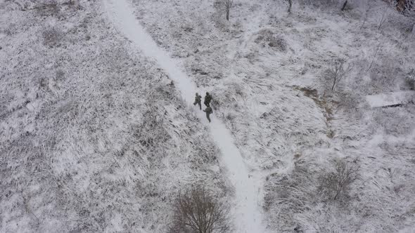 Threesoldiers in Full Uniforms Go to the Places of Hostilities in Winter