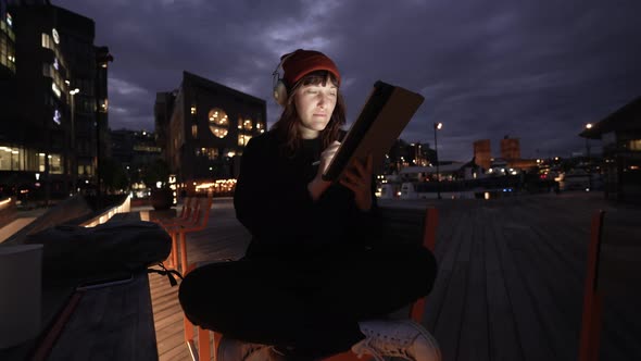 Woman Using Tablet Computer in City at Night