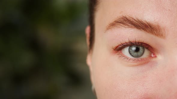 Closeup of a Eye Blinking Opening and Closing Halfface Portrait