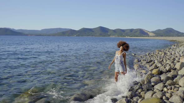 Slow motion shot of young woman standing in water at the beach