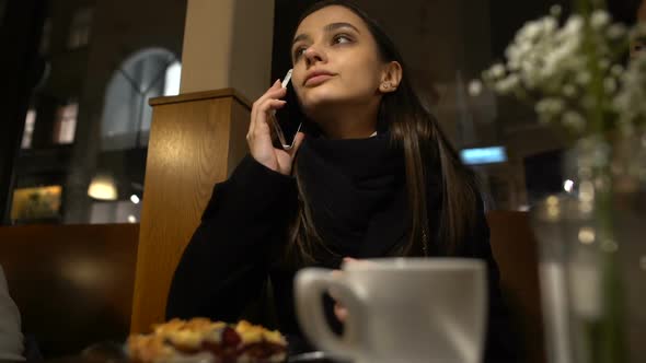 Woman Sitting in Cafe Talking Phone With Boyfriend Late for Date, Relationship