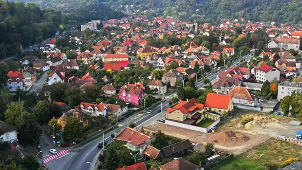 Aerial drone view of Sighisoara, Romania. Roads with cars, greenery and buildings