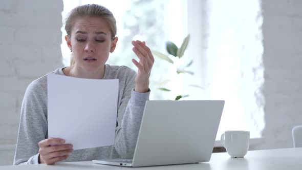 Young Woman Reading Document and Gets Upset for Loss