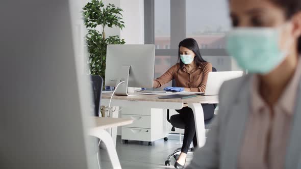 Video of women in protective face mask working in office. Shot with RED helium camera in 8K.