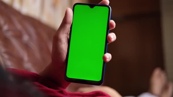 Women Lying on Sofa Using Smart Phone with Green Screen