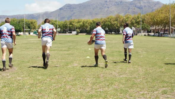 Rugby players running on the field 