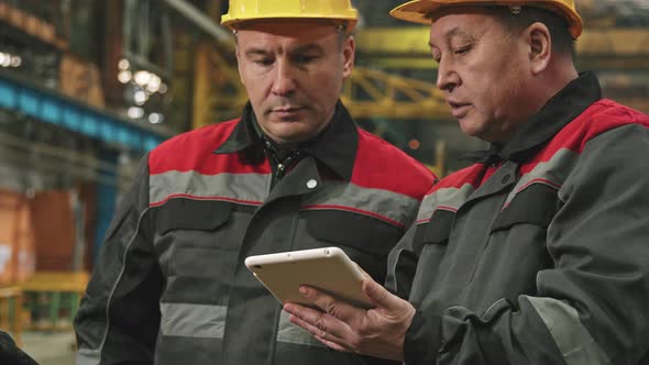 Plant Supervisor And Employee Talking In Assembly Shop