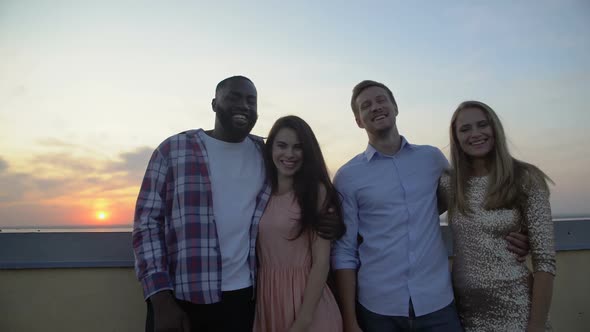 Multiracial Group of Friends Hugging and Smiling at Camera, Standing on Terrace