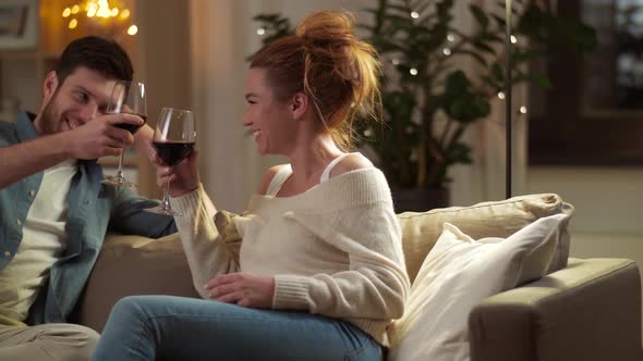 Happy Couple Drinking Red Wine at Home in Evening 