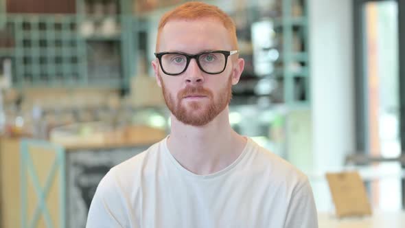 Portrait of Serious Redhead Man Looking at Camera