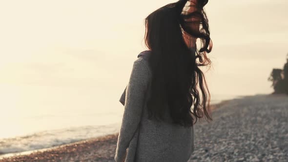 Cheerful Brunette Girl Is Resting on Shore Near Sea in Evening Time, Moving