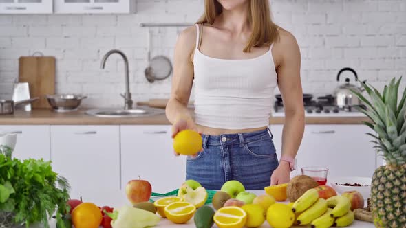 Young woman with muscular body in the kitchen.