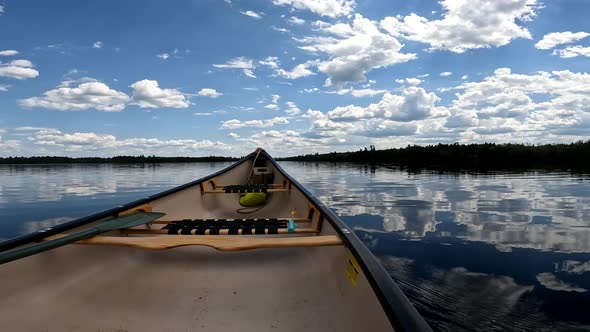 Crossing calm lake in Canadian canoe relaxing perspective