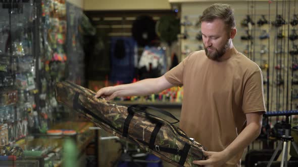 Bearded Man in a Fishing Tackle Shop Getting Ready for a Fishing Trip