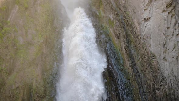 Closeup of a Large Waterfall in a Rocky Mountainous Area, Slow Motion Drop of Water From a Great