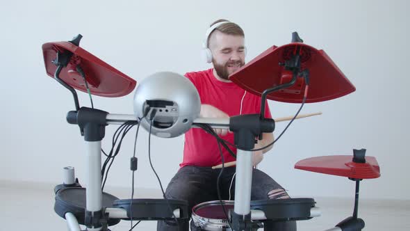 Concept of Hobby and Music Making. Young Man Playing Drums at Home or in a Recording Studio